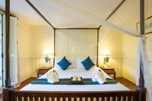 曼谷老友记酒店的一间卧室配有一张带蓝色枕头的大床