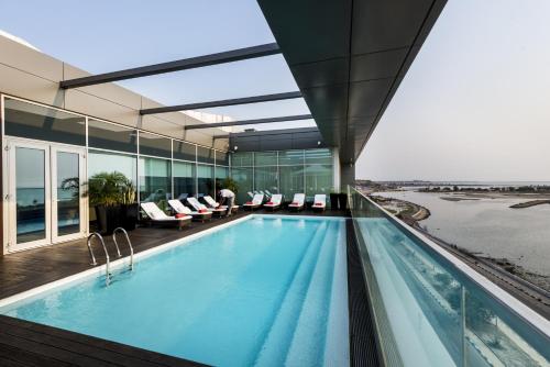 罗安达碧野酒店的一座带窗户的建筑中的游泳池