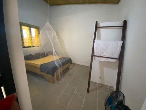 Palmarin NguèdjPetite maison en bord de mer的卧室配有一张床,房间内设有梯子