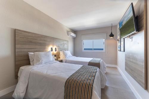 埃斯特角城Nobile Hotel Montoya的酒店客房设有两张床和一台平面电视。