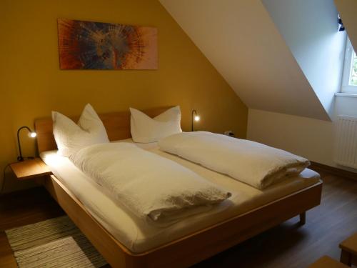 VipperowLindenhof Wohnung 3, Dachgeschoß的一张带白色床单和枕头的床