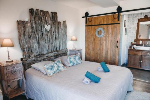 FéronAu charme d'antan的一间卧室配有一张带大型木制床头板的床