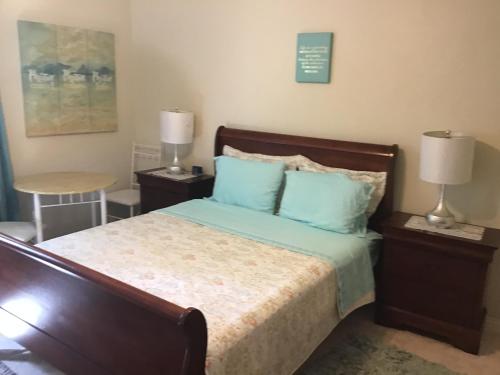 蒙特哥贝Hills Royale Villa -Ironshore Montego Bay的一间卧室配有一张带蓝色枕头的床和一张桌子