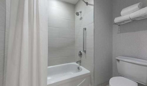悉尼The Simon Hotel Sydney的白色的浴室设有淋浴帘和卫生间。