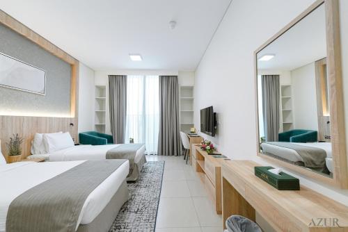 迪拜Azur Regency Hotel Apartments的酒店客房,设有两张床和镜子