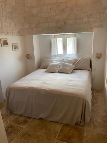 洛科罗通多trulli mancinella的卧室配有一张带两个枕头的大白色床