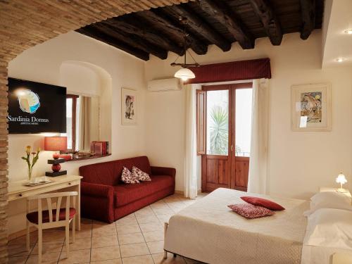 卡利亚里撒丁尼亚多莫斯酒店的一间卧室配有一张床和一张红色的沙发