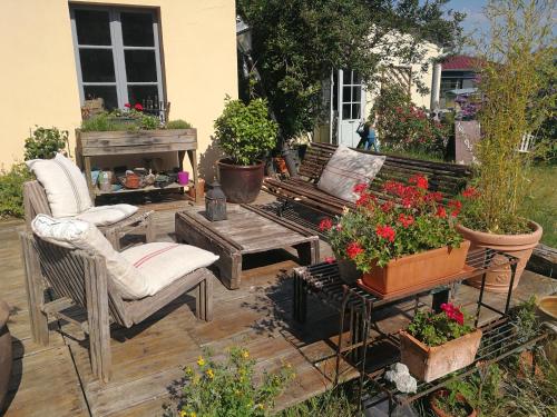 贝莱姆LA GUINGUETTE DE BELLEME的庭院配有椅子、桌子和鲜花