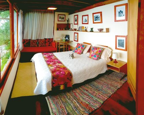 明多Finca Petrona的一间卧室配有一张床、一张桌子和一个窗户。