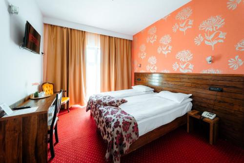 百乐费利克斯Hotel Aqua Thermal Spa的配有一张床和一张书桌的酒店客房