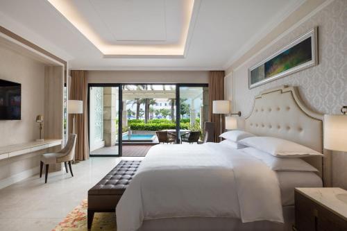 岘港Sheraton Grand Danang Resort & Convention Center的卧室设有一张白色大床和一个庭院。