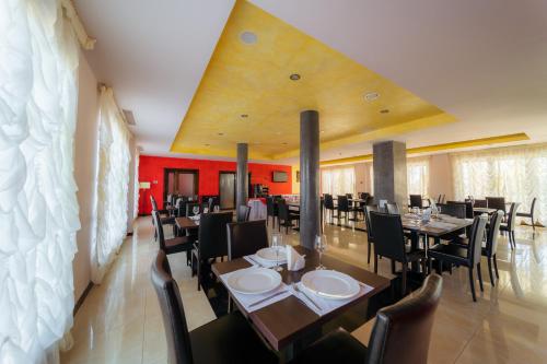 百乐费利克斯Hotel Aqua Thermal Spa的一间设有桌椅和红色墙壁的餐厅
