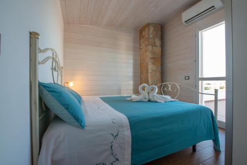 滨海波利尼亚诺Villa Barnaba Country House & Pool的一间卧室配有一张带蓝色床单的床和一扇窗户。