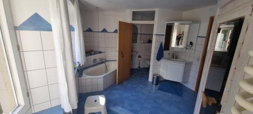 KastelhofParadies 1的蓝色和白色的浴室设有浴缸和水槽