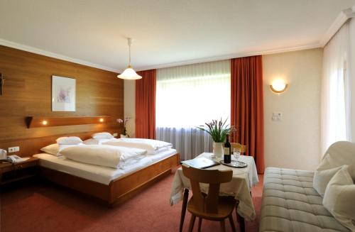 布雷根茨沃尔德地区奥Haus Alpina的一间卧室配有一张床、一张桌子和一张沙发
