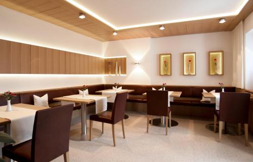 布雷根茨沃尔德地区奥Haus Alpina的一间在房间内配有桌椅的餐厅