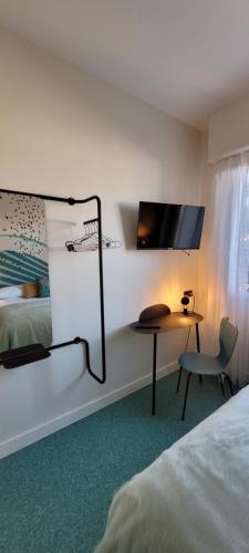 鲁瓦扬Seakub hotel的酒店客房设有一张床、一张书桌和一台电视机。