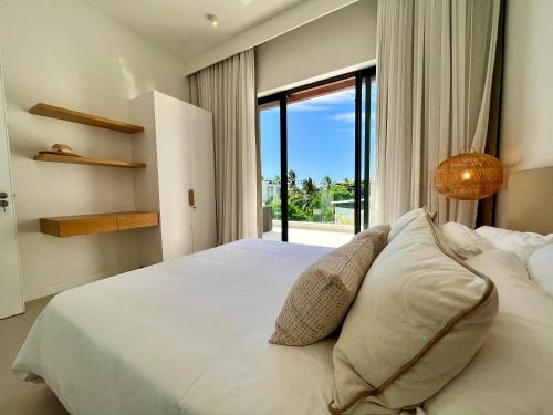 贝尔马尔Exclusive beachfront penthouse的卧室配有白色的床和大窗户