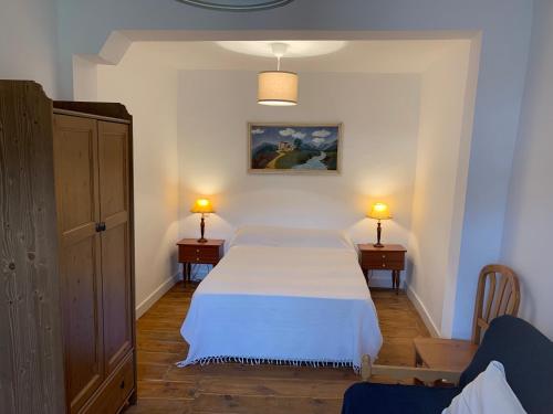 Alameda del ValleLa Toscana en Lozoya的卧室配有白色的床和2个床头柜