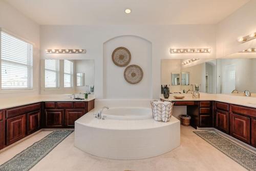 萨克拉门托Elegant Mediterranean Hotel Style Home W Hot Tub的带浴缸和大镜子的大浴室