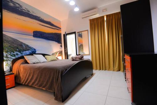 克伦蒂Seaside Xlendi apartment的一间卧室配有一张壁画床