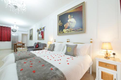 斯利马Di Valentina Boutique Living的一间卧室配有一张白色大床,上面有红色玫瑰花瓣