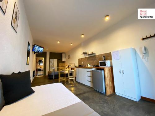 皮科将军镇Beatriz Apartamentos - Monoambientes的客房设有一张床和带冰箱的厨房