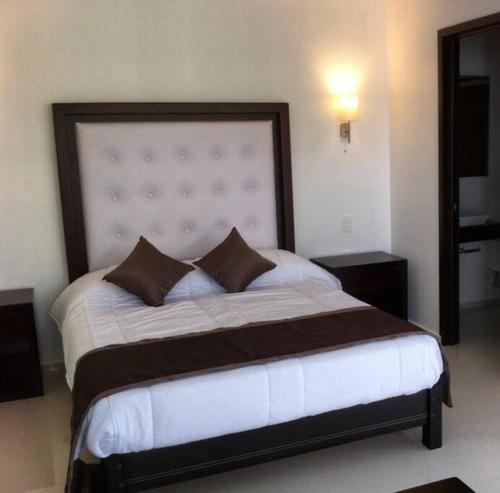 Los PascualesLuxurious Surf Resort in Pascuales Mexico Room 3的一间卧室配有一张大床和大床头板