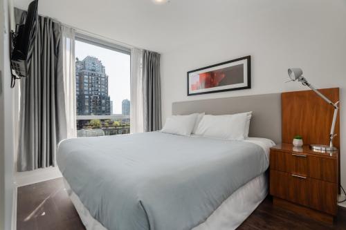 温哥华Level Vancouver Yaletown - Seymour的卧室设有一张白色大床和一扇窗户。