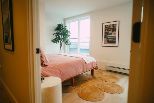 哈利法克斯NEW Stylish 2BR Condo with Views in North End的卧室配有一张铺着盆栽植物的床。