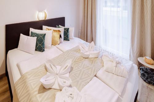 凯斯特海伊Alexandra Apartman的卧室配有一张白色床和弓形床