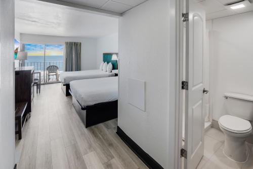 默特尔比奇蓝色大西洋套房酒店的酒店客房设有一张床、一个卫生间和一间浴室。
