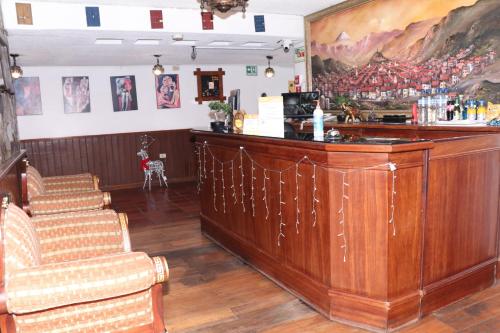 基多Hostal La Catolica的一间酒吧,位于带柜台和椅子的房间内