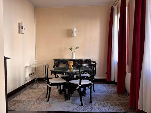 博洛尼亚Piazza Maggiore Luxury Apartment的一间用餐室,配有黑色的桌子和椅子