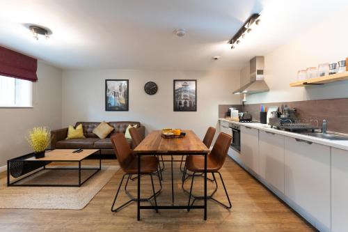 曼彻斯特High Street Town House的厨房以及带桌子和沙发的客厅。