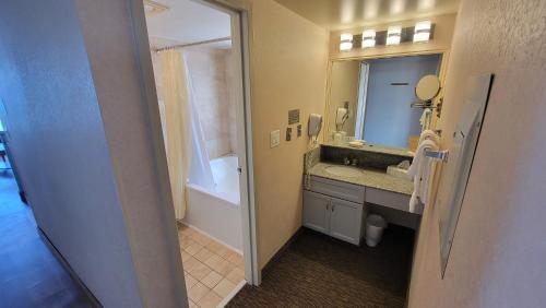 弗吉尼亚海滩弗尔赛欧度假酒店的浴室配有盥洗盆、镜子和浴缸