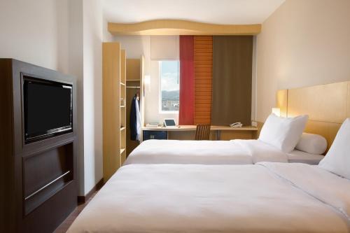 万隆宜必思万隆巴斯德酒店的酒店客房设有两张床和一台平面电视。