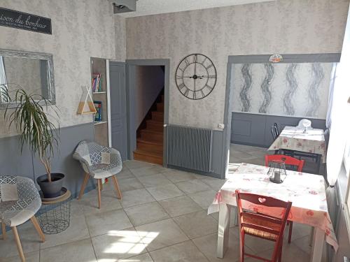 DrosnayChez Marie的一间设有桌椅和墙上时钟的房间
