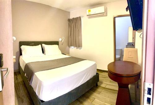 巴兰基亚Hotel Yivinaca的酒店客房配有一张床铺和一张桌子。