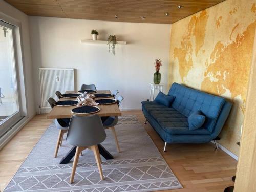 魏因海姆Tolle Wohnung mit Panoramablick的客厅配有桌子和蓝色沙发