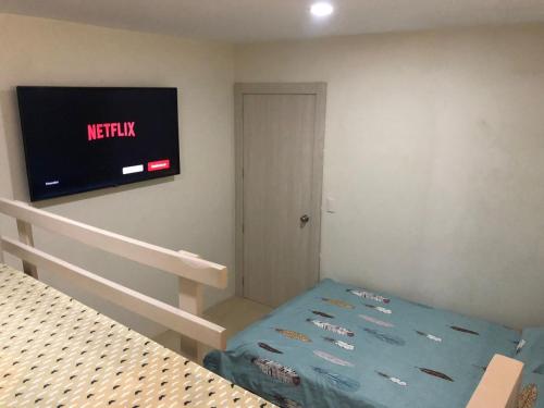 萨利纳斯Salinas Bay Suite的卧室配有一张床,墙上配有电视。