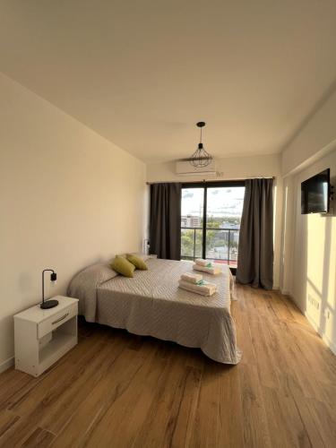 布宜诺斯艾利斯Monoambiente Urquiza的一间卧室设有一张床和一个大窗户