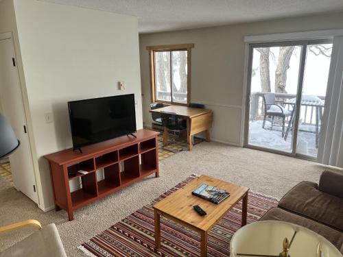 布雷纳德The Point - On Gull Lake的客厅配有平面电视和桌子。