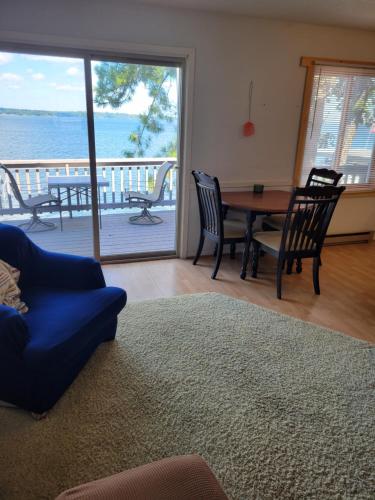 布雷纳德The Point - On Gull Lake的客厅配有桌椅,享有海景。