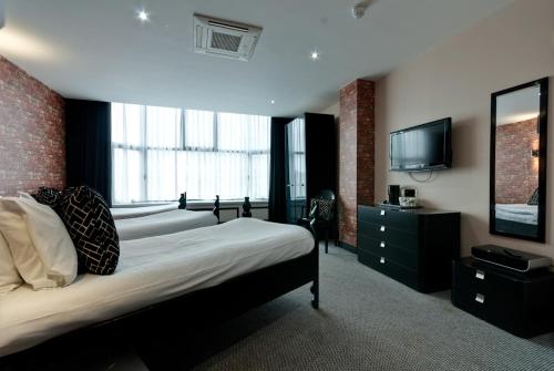 利物浦普瑞沃克斯公寓式酒店的一间卧室配有两张床和一台平面电视