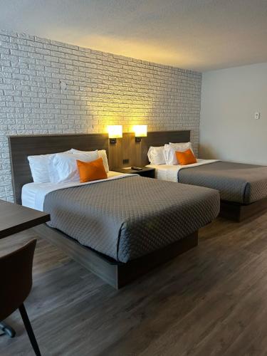 蒙洛里耶Complexe Dix80的酒店客房带两张床和砖墙