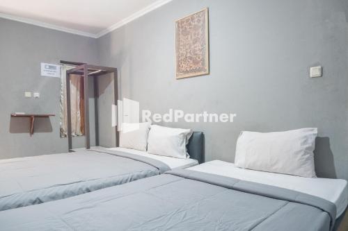 日惹Crown Residence near Tugu Yogyakarta Mitra RedDoorz的两张睡床彼此相邻,位于一个房间里