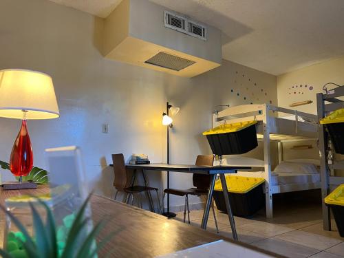 好莱坞Bposhtels Hollywood Florida的客房配有双层床、桌子和书桌。