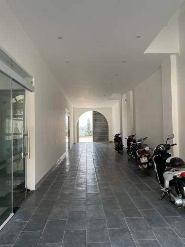 波来古市Nine Hotel Gia Lai的建筑物内停放摩托车的走廊
