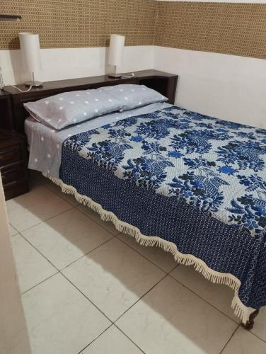 伊洛Departamento Amoblado en Urba. Ilo的一间卧室配有一张带两盏灯的蓝色和白色的床。